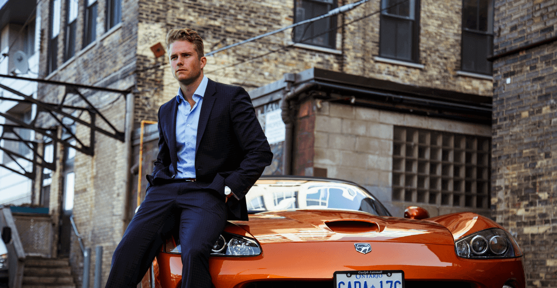 A man standing next his supercar